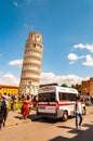 The famous leaning Tower of Pisa or La Torre di Pisa at the Cathedral Square, Piazza del Duomo full of tourists and ambulance on Royalty Free Stock Photo