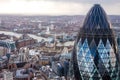 Famous London Gherkin tower with a Tower Bridge on a background