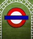 Famous London Underground sign on green tile wall