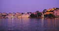 Udaipur Lal ghat, houses and City Palace on bank of lake Pichola with water ripple. Sunset at Udaipur, India Royalty Free Stock Photo