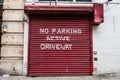 Red garage door with white inscription ` No Parking active driveway`