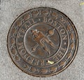 Famous metal Freedom Trail sign seen set within concrete on a Boston city sidewalk in autumn. Royalty Free Stock Photo