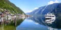 Famous mountain village in the Austrian Alps on a warm autumn day. Pleasure boat on the lake. Royalty Free Stock Photo