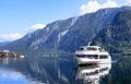 Famous mountain village in the Austrian Alps on a warm autumn day. Pleasure boat on the lake. Royalty Free Stock Photo