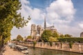 Notre Dame cathedral with houseboats on Seine during spring time in Paris, France Royalty Free Stock Photo