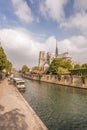 Notre Dame cathedral with houseboats on Seine during spring time in Paris, France Royalty Free Stock Photo
