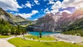 Famous Oeschinensee with Bluemlisalp mountain on a sunny summer day. Panorama of the azure lake Oeschinensee. Swiss alps, Royalty Free Stock Photo