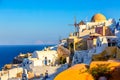 Famous Oia village with traditional white houses and windmills during summer sunny day Santorini island, Greece. Greece vacation Royalty Free Stock Photo