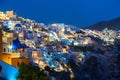 Famous Oia village with white houses and blue dome churches during sunset on Santorini island, Aegean sea, Greece Royalty Free Stock Photo