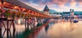 Famous old wooden Chapel Bridge Kapellbrucke, landmark 1300s wooden bridge with grand stone water tower & a roof decorated with Royalty Free Stock Photo