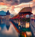 Famous old wooden Chapel Bridge Kapellbrucke, landmark 1300s wooden bridge with grand stone water tower & a roof decorated with Royalty Free Stock Photo