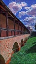 Photographic art picture of famous orthodox monastery and rusty roof of its surrounding wall under blue cloudy sky in summer