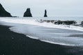 Famous panorama of the black sand beach in Iceland. Dark waves of Atlantic ocean waves covering the sand Royalty Free Stock Photo
