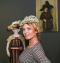 Famous people in the art gallery. Vintage exhibition of women`s clothing and hats. The exhibition has many journalists who take pi