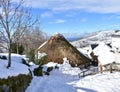 Famous Piornedo mountain village after a snowfall with ancient round Palloza stone houses with thatched roofs. Lugo, Spain. Royalty Free Stock Photo