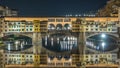 Famous Ponte Vecchio bridge timelapse over the Arno river in Florence, Italy, lit up at night Royalty Free Stock Photo