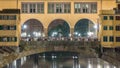 Famous Ponte Vecchio bridge timelapse over the Arno river in Florence, Italy, lit up at night Royalty Free Stock Photo