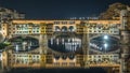 Famous Ponte Vecchio bridge timelapse over the Arno river in Florence, Italy, lit up at night Royalty Free Stock Photo