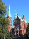 Famous red church historic architecture landmark in Helsinki, Finland with blue sky and vivid green grass