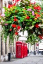 Famous red telephone booths against flowers in Covent Garden street, London, England Royalty Free Stock Photo