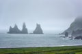 Famous Reynisdrangar rock formations, troll fingers at black sand Reynisfjara beach, foggy landscape, Iceland Royalty Free Stock Photo