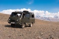 The Famous Russian Dirty Off-Road Van UAZ - 452 In everyday life is called `loaf` Against the background of snow-capped peaks Royalty Free Stock Photo