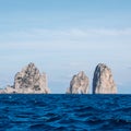 Famous sea stacks with arch, faraglioni, off the coast of Capri in the Bay of Naples on the Mediterranean Sea, Italy.