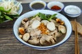 Thai style noodle soup served with vegetable on wood table