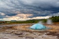 Famous Strokkur fountain geyser hot blue water explosion with cl