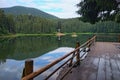 Famous Synevyr mountain lake. Gorgeous morning scenery with spruce forest and clouds reflecting on a water surface.