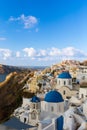 Famous three blue domes in Santorini. Oia village. White church, blue dome. Cloudy sky. Royalty Free Stock Photo