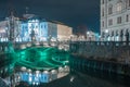 The famous three bridges in Ljubjana on a cold winter night with bright lights and reflection in Ljubljanica river