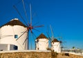 Famous tourist attraction of Mykonos, Greece. Traditional whitewashed windmills, summer, blue sky, cruise liner. Travel