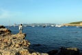 Famous and touristic cove of Ibiza called Cala Bassa and a woman on her back standing on a rock