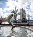 Famous tower bridge with dolphine sculpture drawbridge bright cloudy day london
