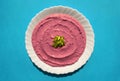 Beet hummus in a white plate on blue background Royalty Free Stock Photo