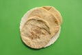 Famous traditional Arabic pita bread in white plate on green background. Royalty Free Stock Photo