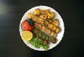 Grilled chicken shashlik, lamb, beef kofta kebab, tomato, parsley, lemon on white plate on dark wooden background Royalty Free Stock Photo