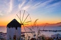 Famous traditional white windmill overlook bay, Mykonos, Greece at sunset sky. Beautiful sky, great colorful clouds Royalty Free Stock Photo