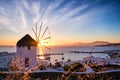 Famous traditional white windmill overlook port and harbor of Mykonos, Cyclades, Greece at sunset sky. Beautiful sky Royalty Free Stock Photo