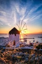 Famous traditional white windmill overlook port and harbor of Mykonos, Cyclades, Greece at sunset sky. Beautiful sky Royalty Free Stock Photo