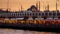Famous Turkish restaurants and fisherman catching fish on the Galata Bridge at sunset in Istanbul. 15th of March, 2023, Turkey,