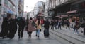 Taksim, Istanbul, Turkey - 03.20.2021: Taksim nostalgic tram moving by passing through crowd of people with protective mask