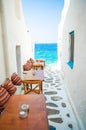 Benches with pillows in a typical greek outdoor cafe in Mykonos with amazing sea view on Cyclades islands Royalty Free Stock Photo