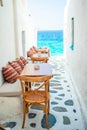 Benches with pillows in a typical greek outdoor cafe in Mykonos with amazing sea view on Cyclades islands Royalty Free Stock Photo