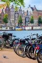 Famous view of Amsterdam - parked bicycles and traditional houses on the Amstel river. Amsterdam, Holland, Netherlands