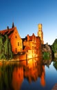 Famous view of Bruges tourist landmark attraction - Rozenhoedkaai canal with Belfry and old houses along canal with tree in the Royalty Free Stock Photo