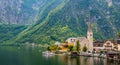 Famous view of Hallstatt city and church near the lake. Mountains in the background. Summer rainy day, soft colors, cloudy weather Royalty Free Stock Photo