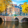 Famous view of the old heart of Amsterdam -  old sloping houses, bridges and canals. Autumn fall day in Amsterdam Royalty Free Stock Photo