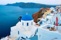 Famous view from viewpoint of Santorini Oia village with blue dome of greek orthodox Christian church Royalty Free Stock Photo